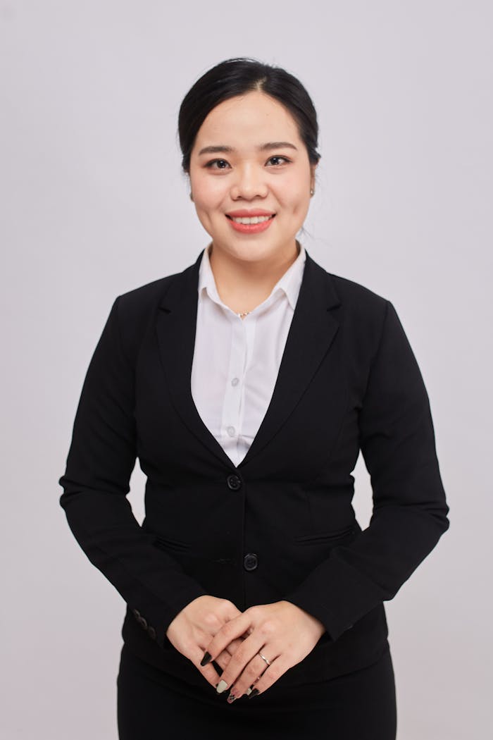 Businesswoman in a suit smiling confidently, ideal for corporate themes.