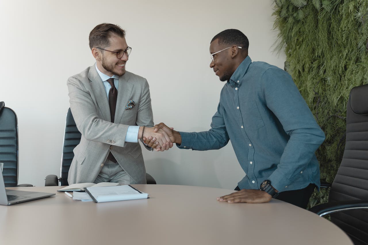 about-02 Two men shaking hands during a professional business meeting in a modern office.